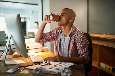Buy stock photo Cropped shot of a young designer drinking coffee while working late in an office