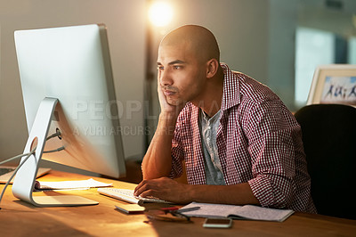 Buy stock photo Cropped shot of a young designer looking bored while working late in an office