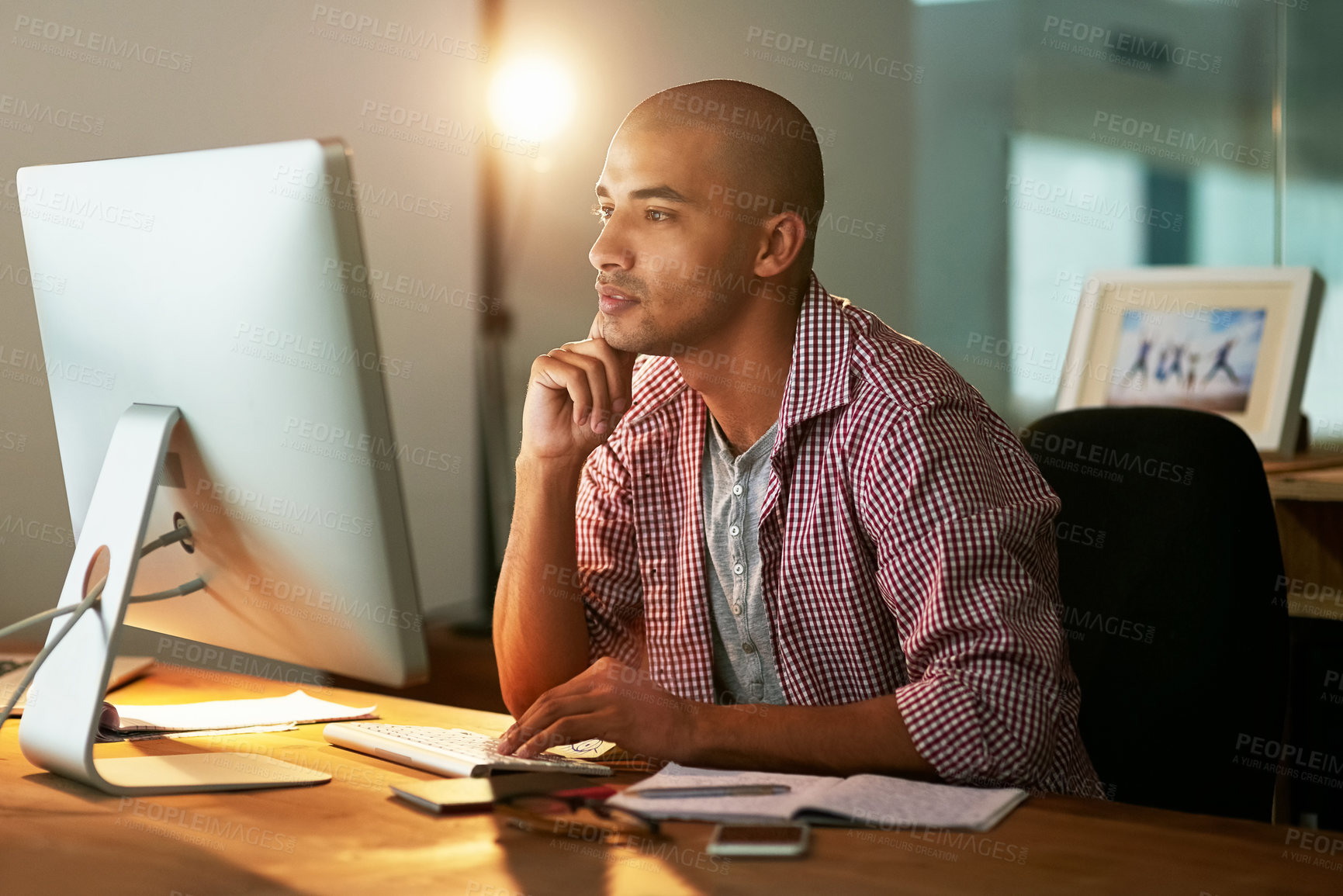 Buy stock photo Creative, man and reading with computer in office at night for research, thinking and thoughts for ideas of web design project. Male designer, late and visualization for website development or online