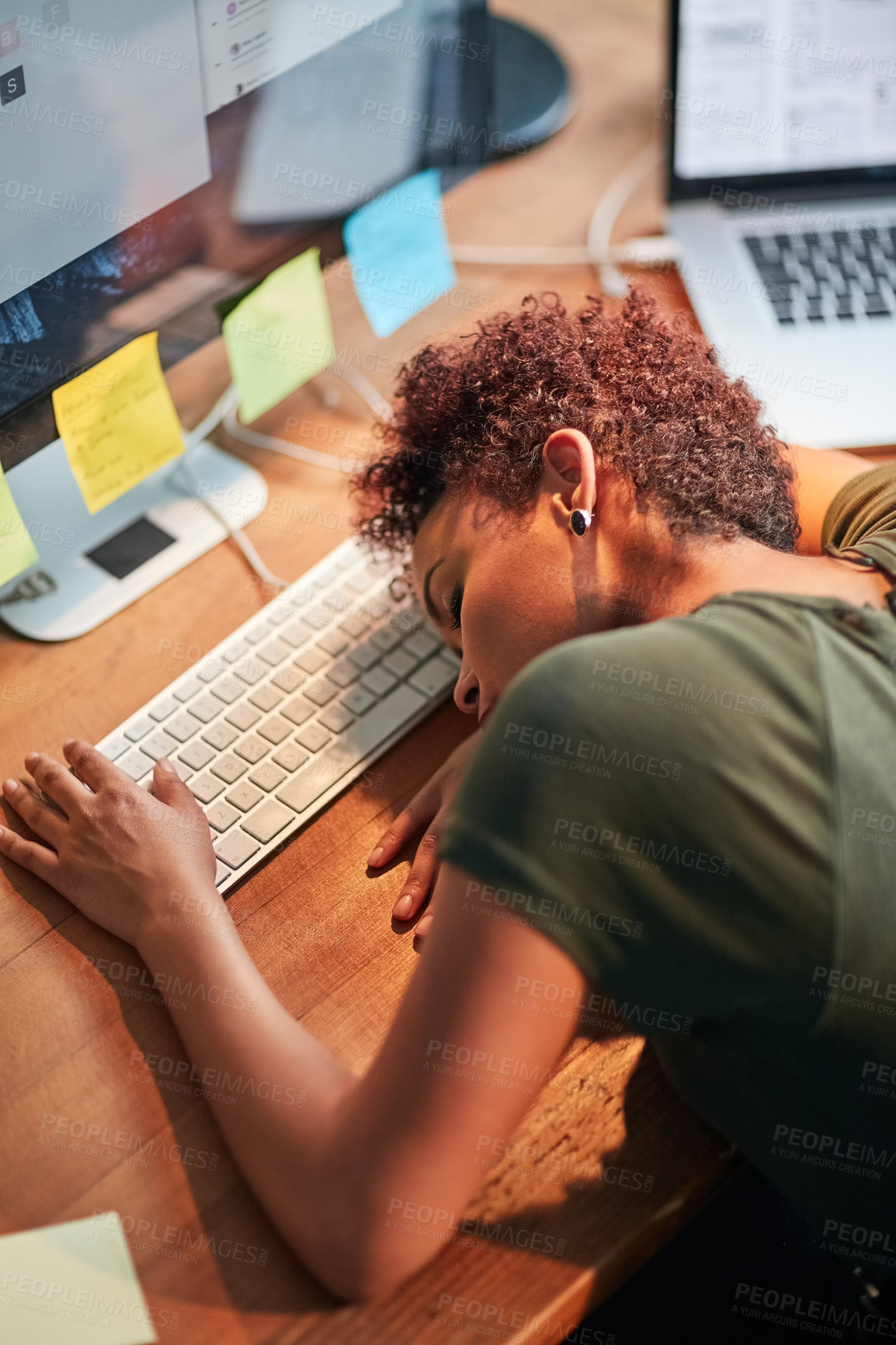 Buy stock photo Shot of an exhausted young businesswoman sleeping with her head on her desk