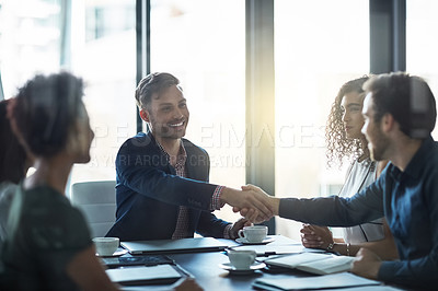 Buy stock photo Shot of a friendly businessman welcoming a new team member in the boardroom