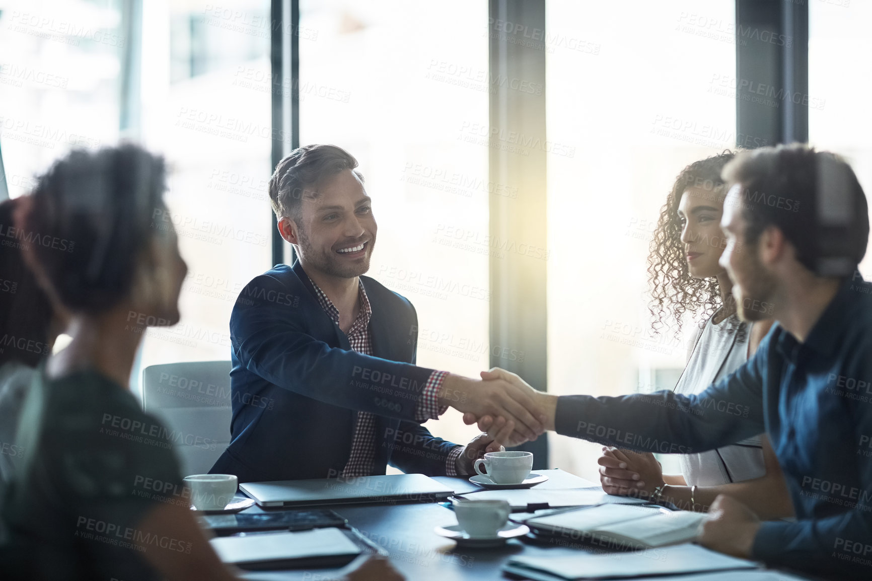 Buy stock photo Shot of a friendly businessman welcoming a new team member in the boardroom