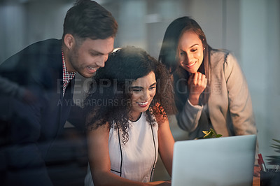 Buy stock photo Shot of three colleagues working together on a laptop in the office