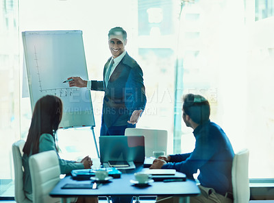 Buy stock photo Shot of a young executive giving a presentation to colleagues in a boardoom