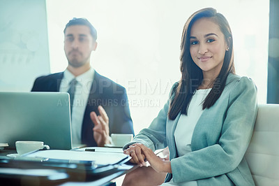 Buy stock photo Portrait of a smiling young executive sitting in a boardroom with a coworker in the background