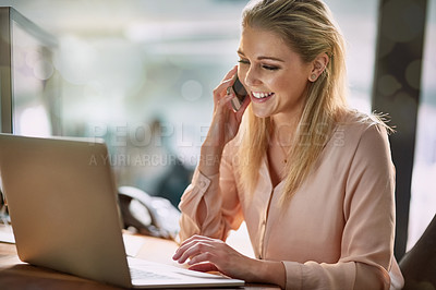 Buy stock photo Shot of a smiling young businesswoman talking on a cellphone while working on a laptop in an office