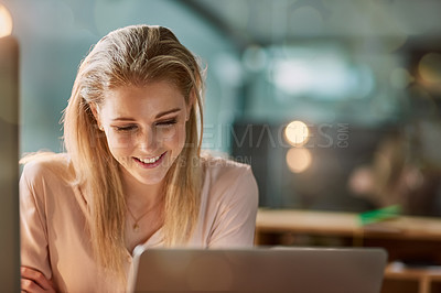 Buy stock photo Shot of a smiling young businesswoman working on a laptop in an office