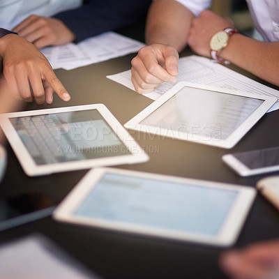 Buy stock photo Closeup shot of a group of professionals using different devices while sitting together at a table in an office