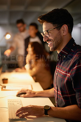 Buy stock photo Shot of a group of businesspeople using their computers while working overtime in the office