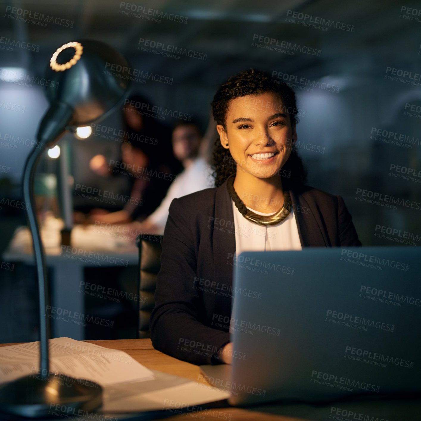 Buy stock photo Portrait of a young businesswoman using her laptop while working overtime in the office