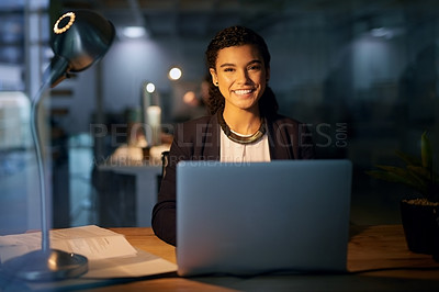 Buy stock photo Portrait of a young businesswoman using her laptop while working overtime in the office