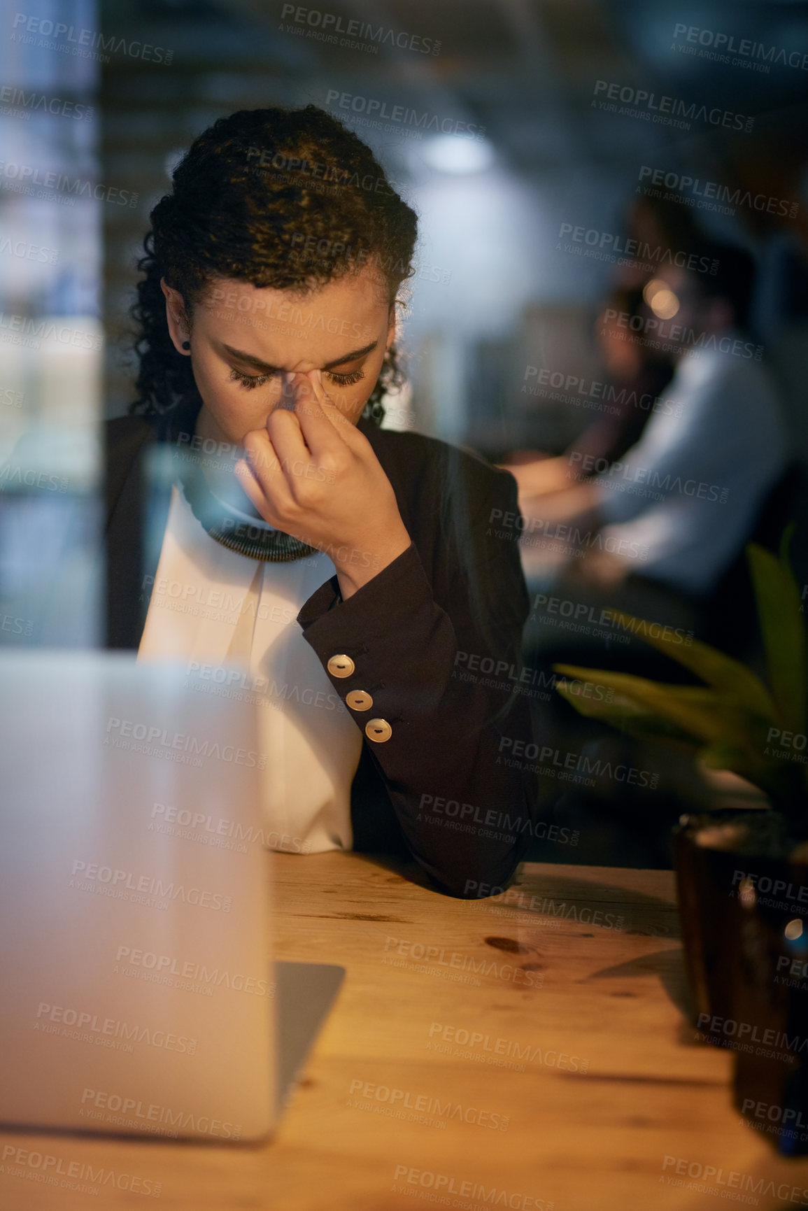 Buy stock photo Shot of a tired businesswoman holding her head while working late in the office