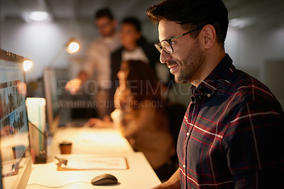 Buy stock photo Shot of a group of businesspeople using their computers while working overtime in the office