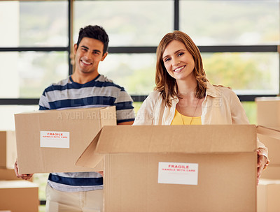 Buy stock photo Portrait of a smiling young couple carrying boxes on moving day