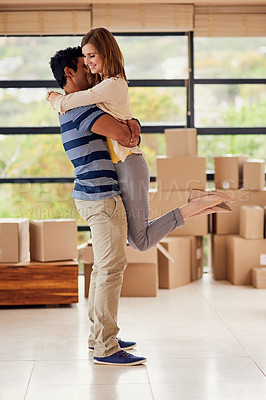 Buy stock photo Shot of a happy young couple embracing while moving into a new home