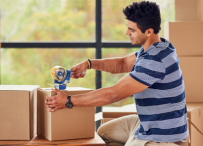 Buy stock photo Shot of a young man taping up boxes on moving day