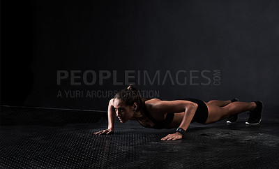 Buy stock photo Studio shot of a woman working out against a dark background