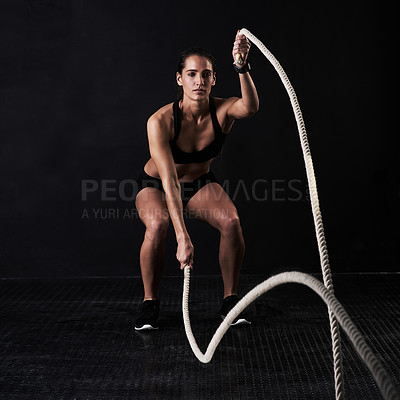 Buy stock photo Studio shot of a woman working out against a dark background