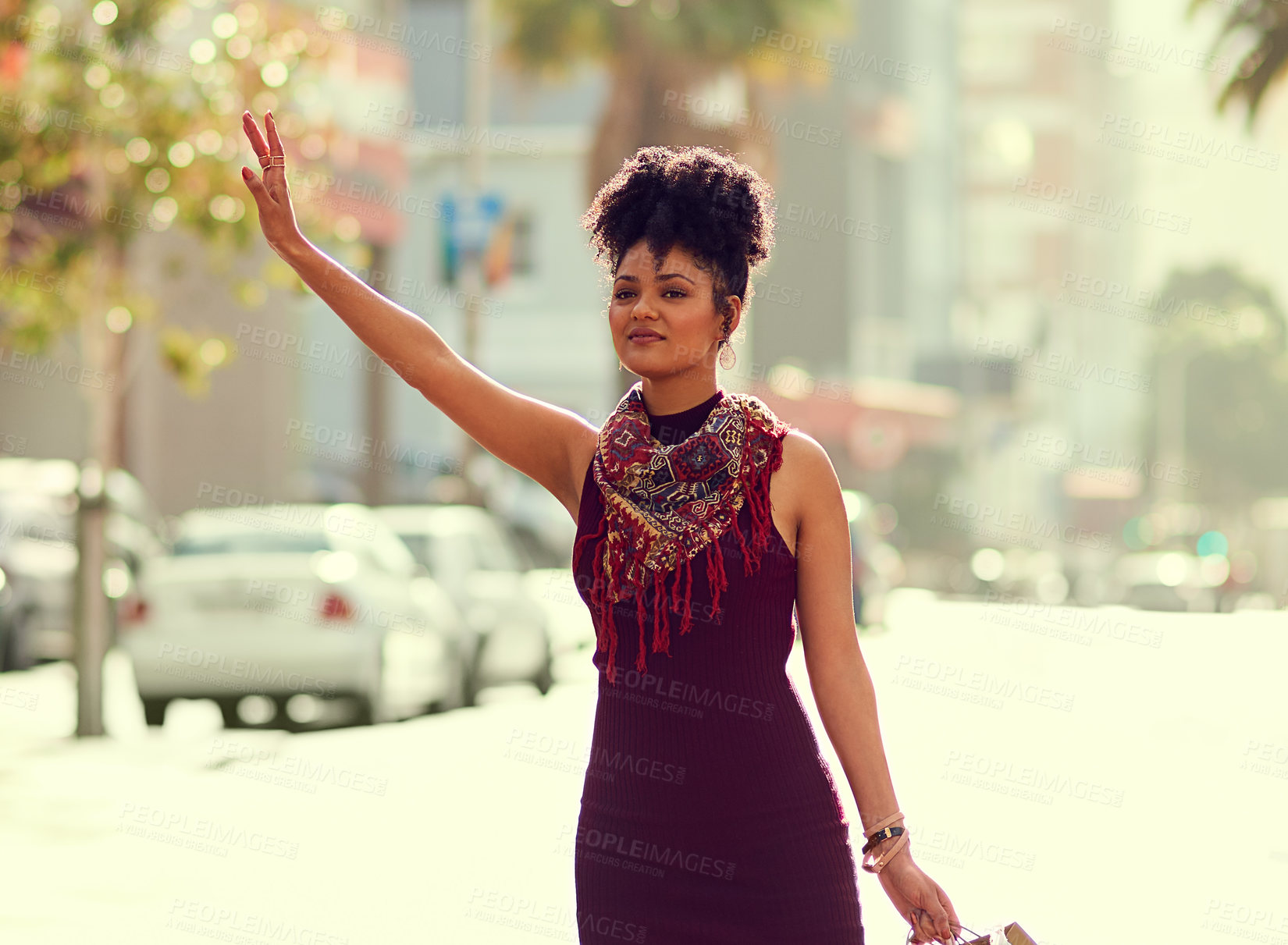 Buy stock photo Shot of a fashionable young woman waving down a cab in the city