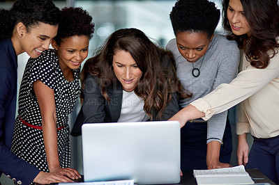 Buy stock photo Shot of a group of businesswomen working together on a laptop in an office