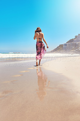 Buy stock photo Rearview shot of a sexy young woman walking on the beach