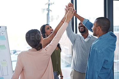 Buy stock photo Shot of a group of coworkers standing in the boardroom table with their hands in a huddle