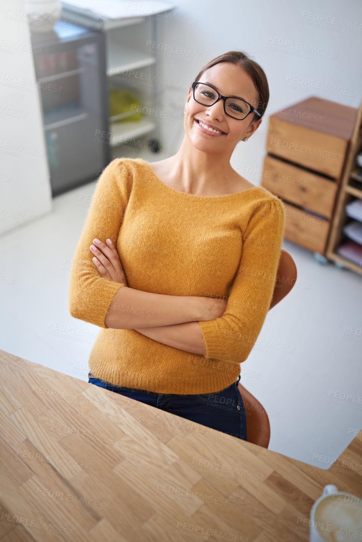 Buy stock photo High angle portrait of a smiling young female designer sitting at her desk in an office