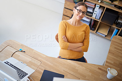 Buy stock photo High angle portrait of a smiling young female designer sitting at her desk in an office