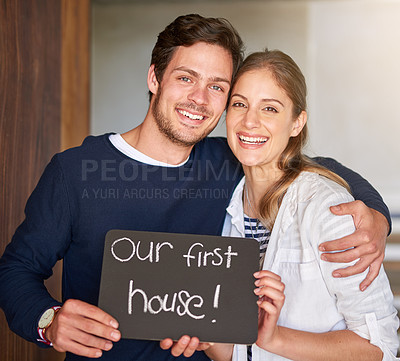 Buy stock photo Portrait of a happy couple holding a sign as they move into their new house