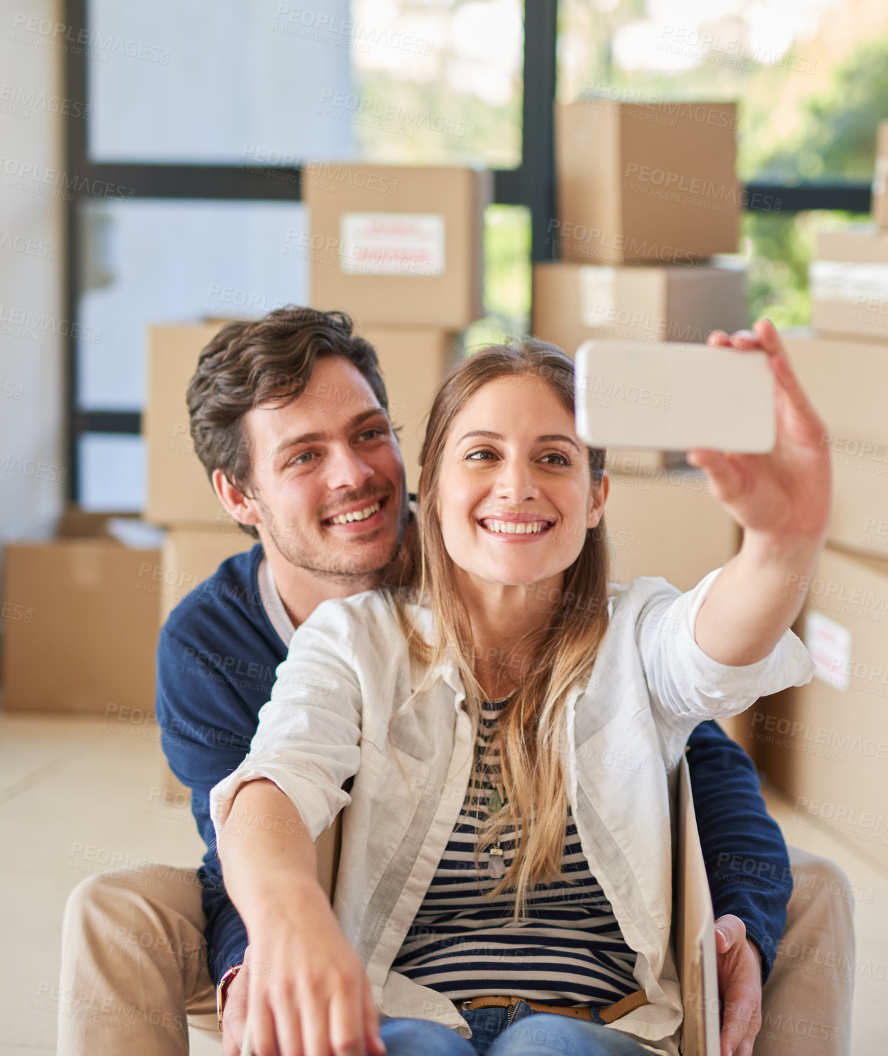 Buy stock photo Happy couple, relax and moving in with selfie for photography, new home or picture at apartment. Young man and woman with smile or playing in box for memory in house, investment or property together