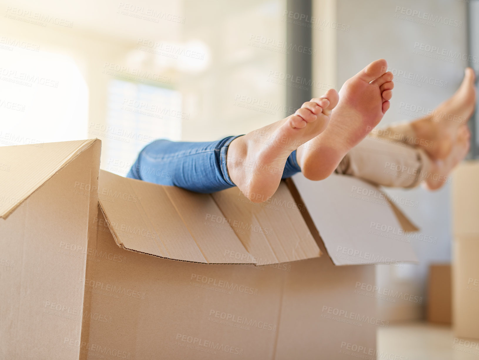 Buy stock photo Couple, feet and moving in with box for new home, relocation or renovation in relax at apartment. Closeup of people barefoot in boxes for house investment, mortgage loan or building in living room