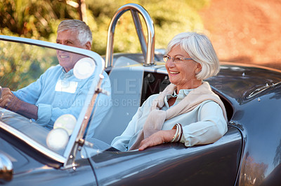 Buy stock photo Shot of a senior couple sitting in a vintage car while on a road trip