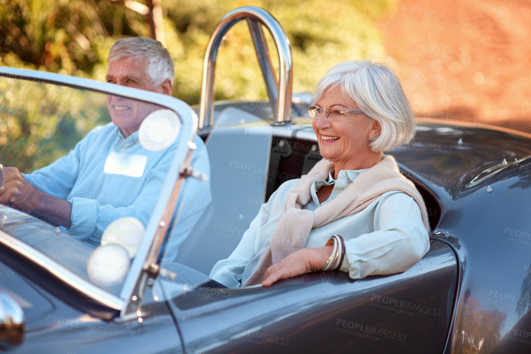 Buy stock photo Shot of a senior couple sitting in a vintage car while on a road trip