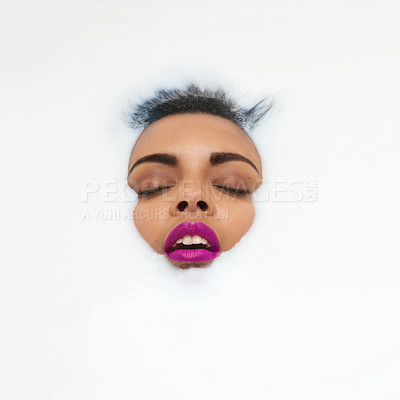 Buy stock photo Shot of a beautiful young woman with her eyes closed submerged in white liquid