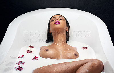 Buy stock photo Shot of a beautiful young woman submerged in white liquid in a bathtub
