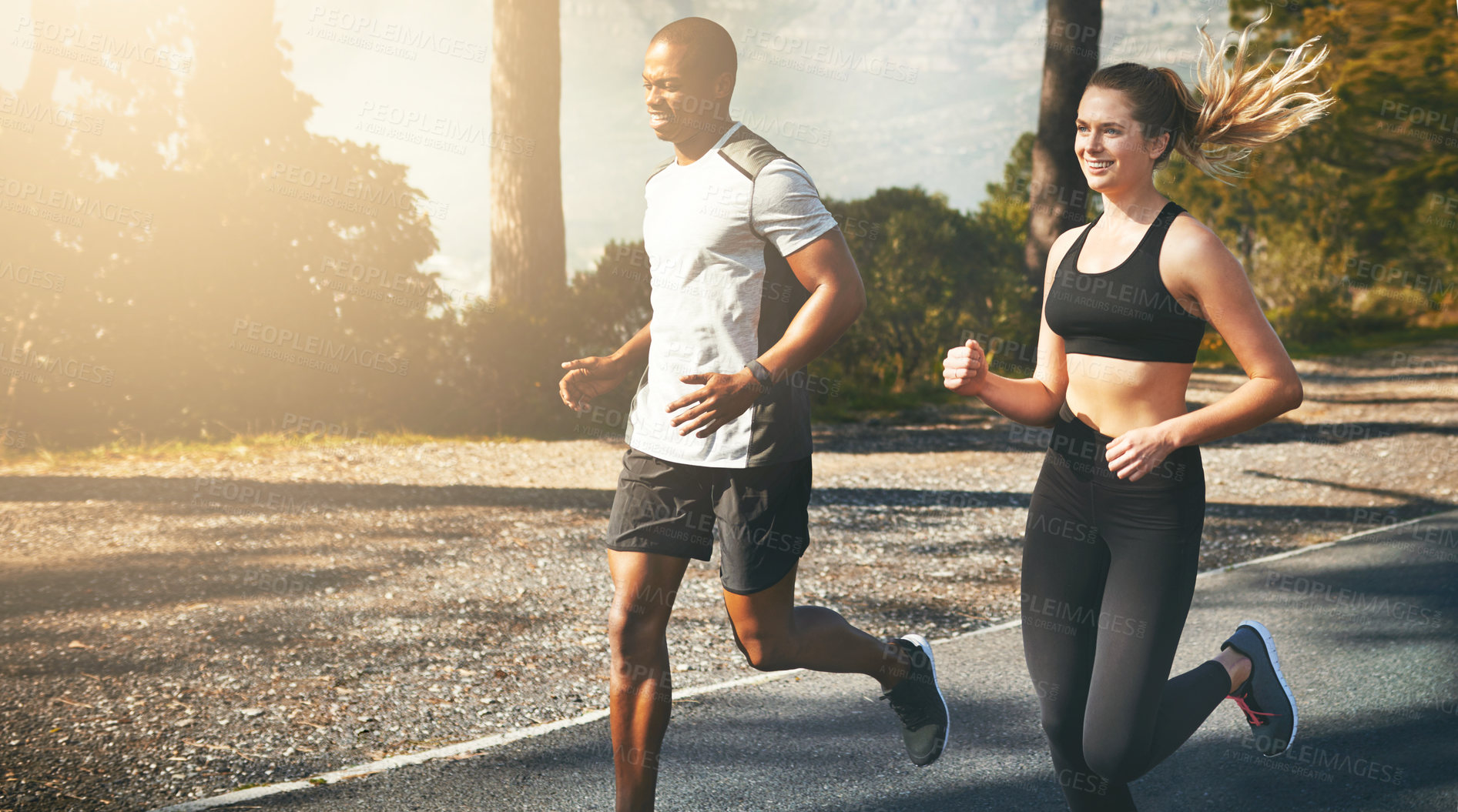 Buy stock photo Shot of a fit young couple going for a run outdoors