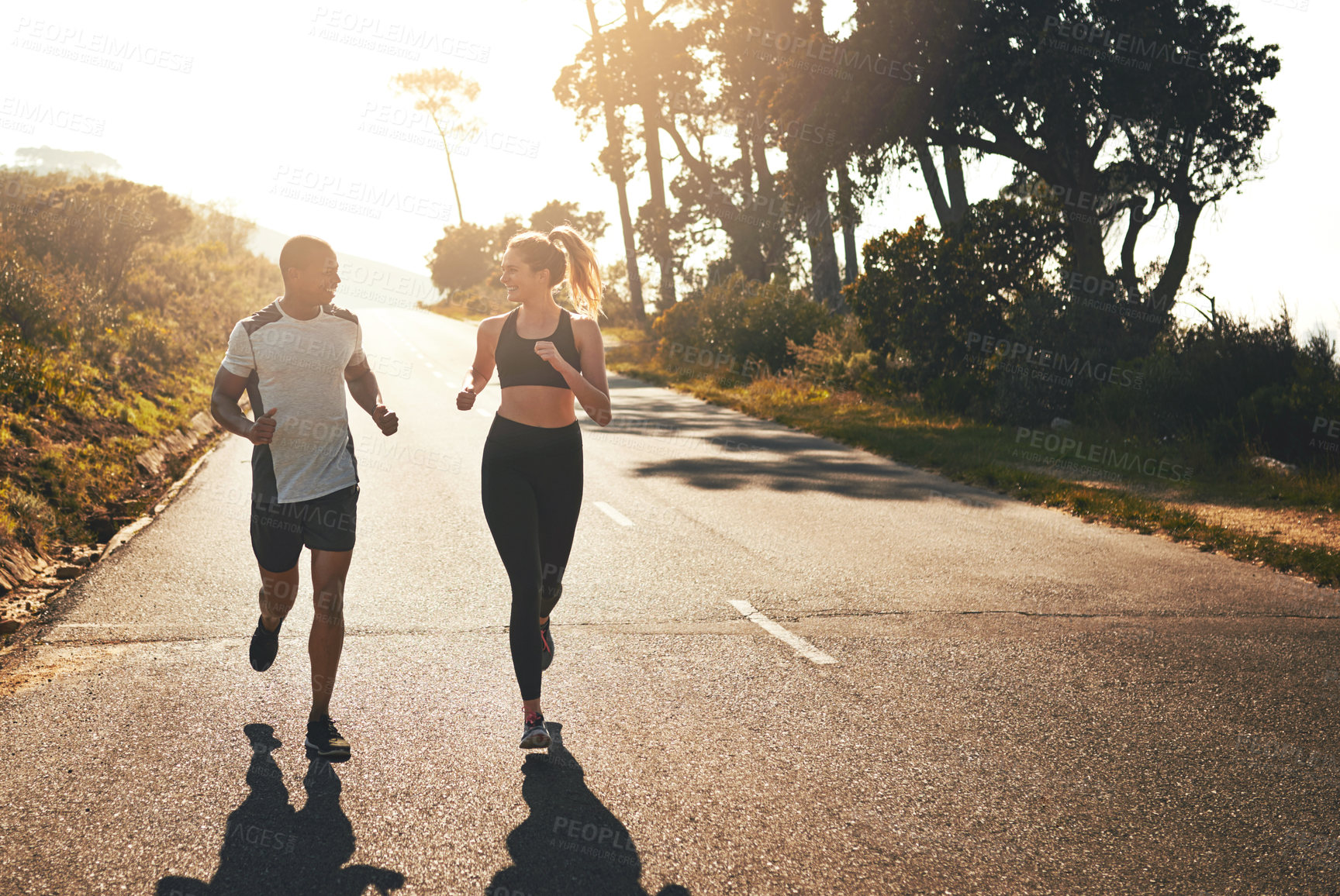 Buy stock photo Shot of a fit young couple going for a run outdoors