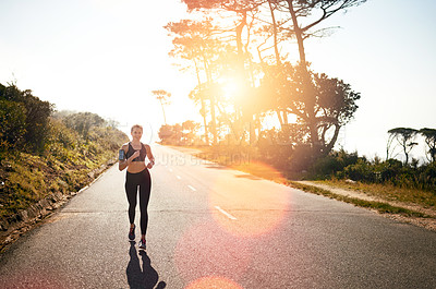 Buy stock photo Shot of a fit young woman going for a run outdoors