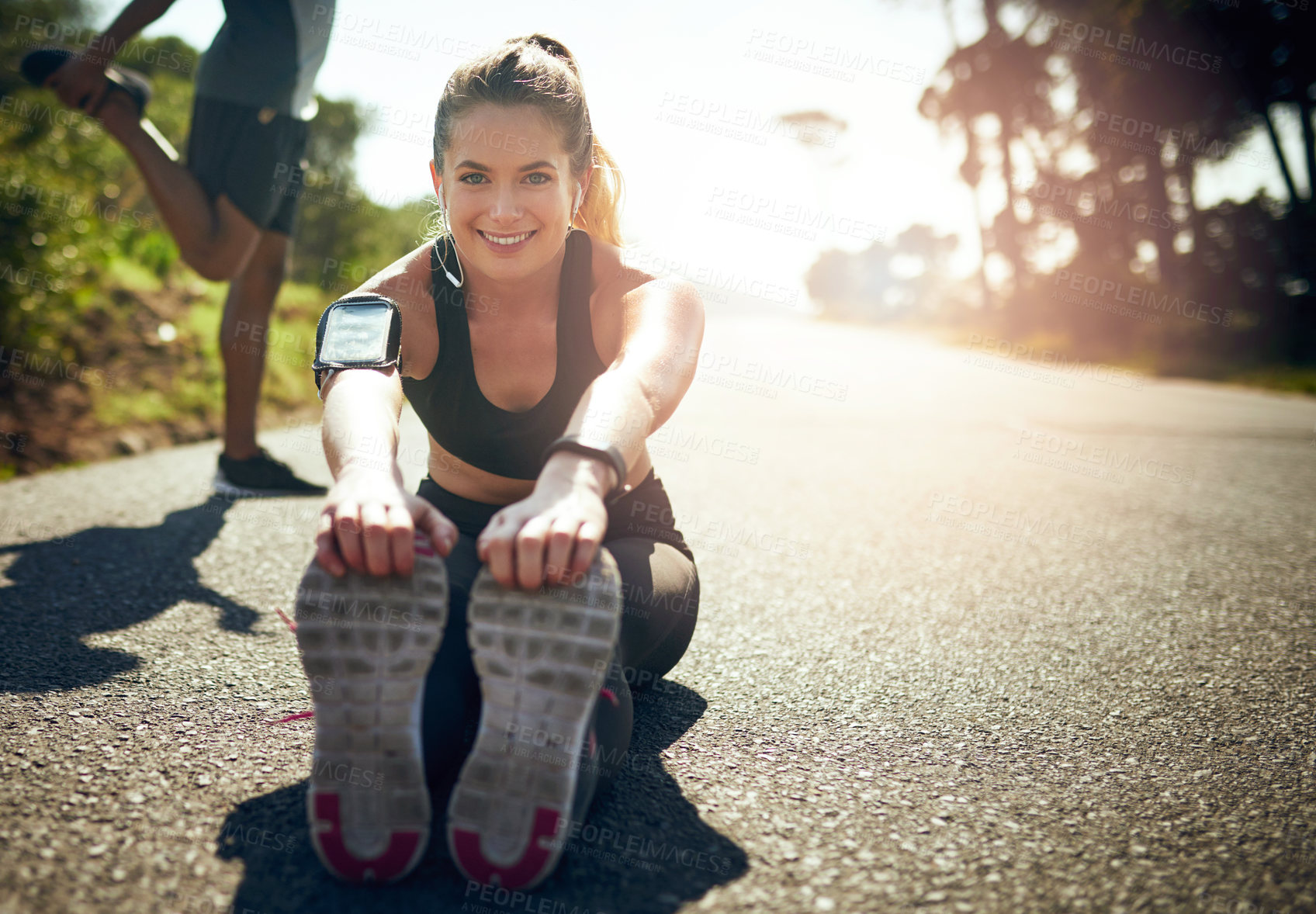 Buy stock photo Shot of a young woman stretching before her run outdoors