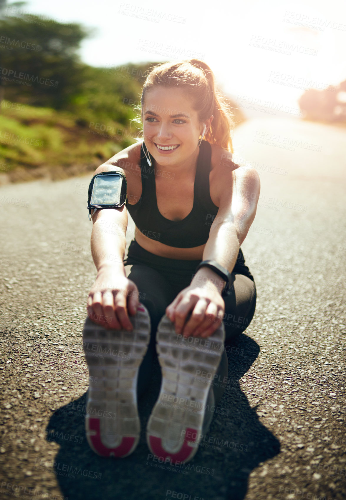 Buy stock photo Shot of a young woman stretching before her run outdoors