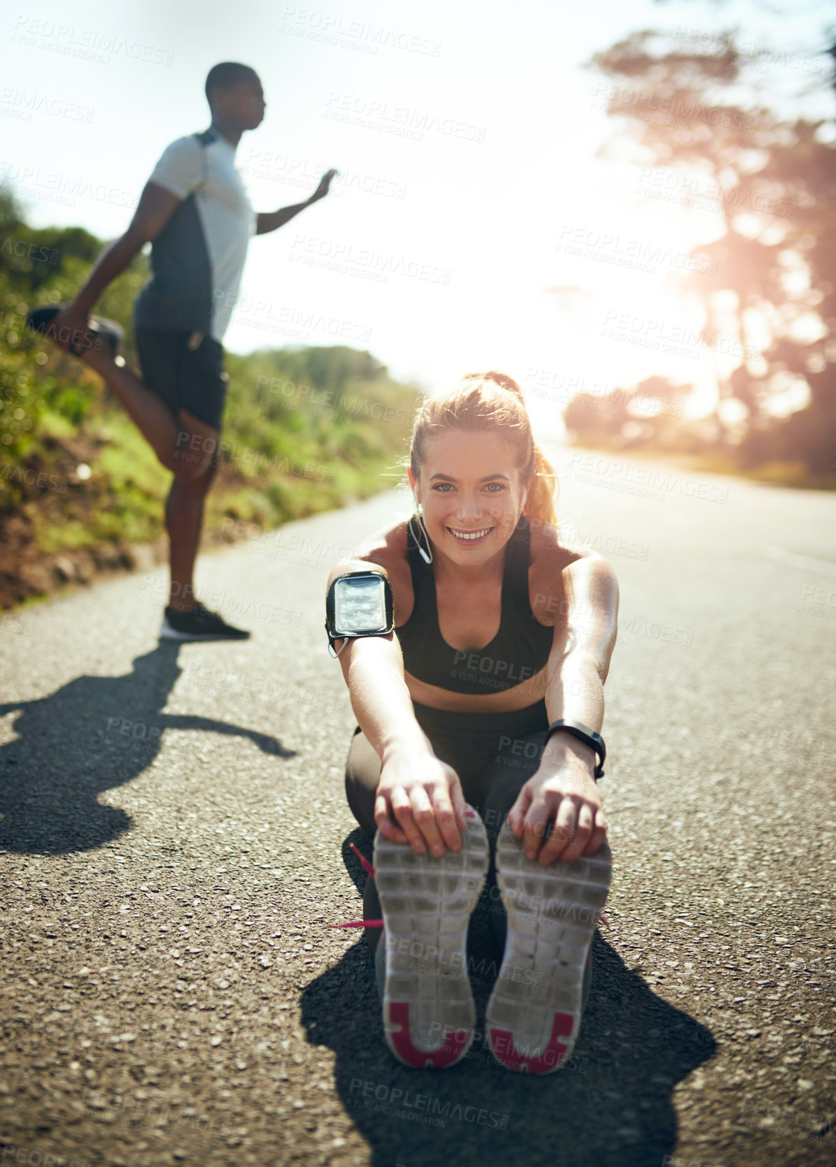 Buy stock photo Shot of a young woman stretching before her run outdoors