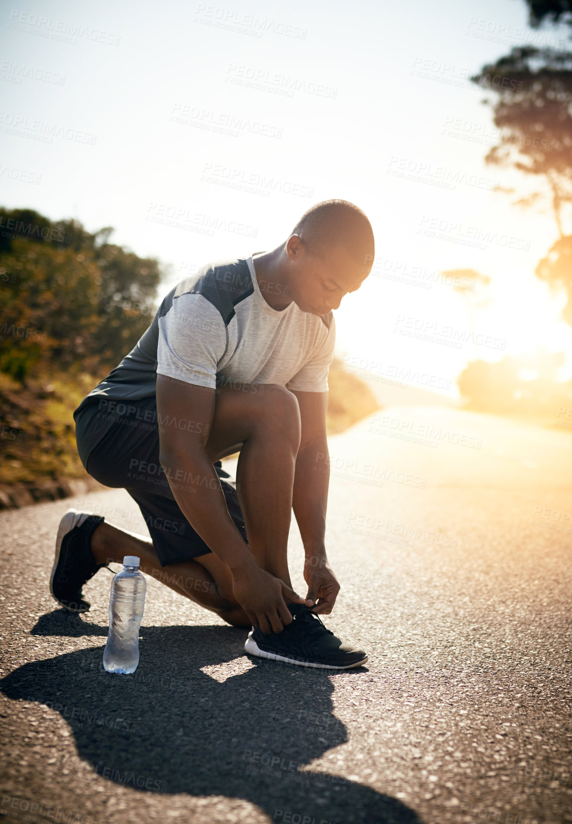 Buy stock photo Fitness, man and tie sneakers outdoor for morning jog, cardio exercise or marathon training. Nature lens flare, person or fasten running shoes for workout, prepare for race or getting ready in street