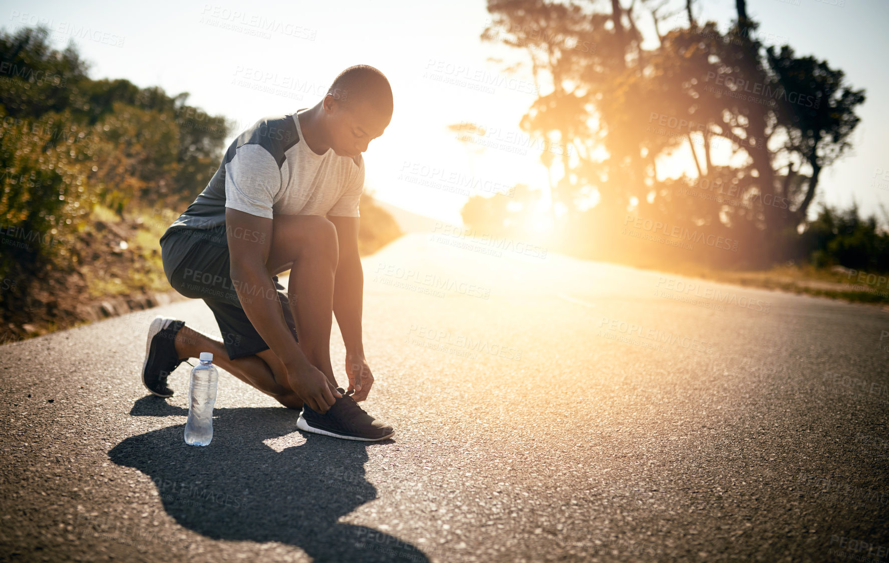 Buy stock photo Fitness, man and tie shoes outdoor for morning jog, cardio exercise or marathon training. Nature lens flare, person or fasten running sneakers for workout, prepare for race or getting ready in street