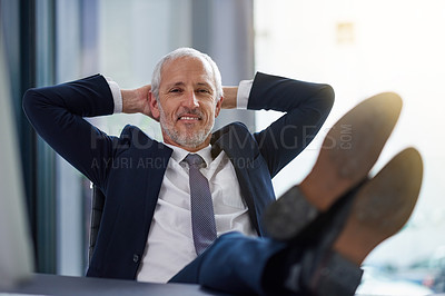 Buy stock photo Portrait of a content mature businessman leaning back in his chair with his hands behind his head
