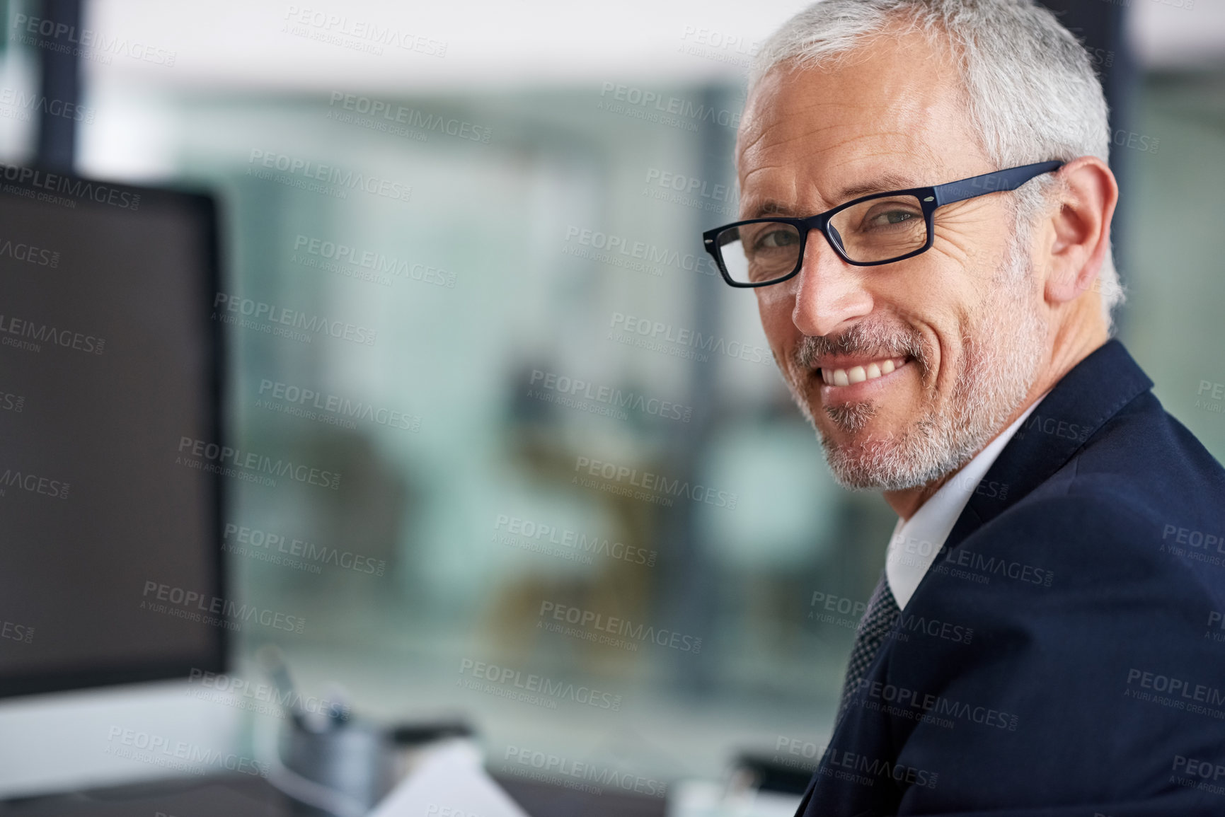 Buy stock photo Portrait of a smiling mature businessman working at his desk in an office