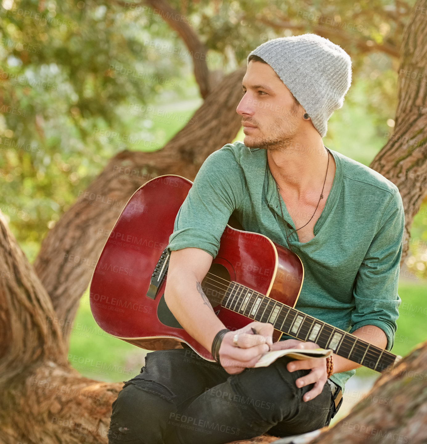 Buy stock photo Outdoor, guitar and man writing of song, thinking and inspiration in park, music and paper in notepad. Nature, tree and person with idea for talent, artist and creativity of musician with instrument