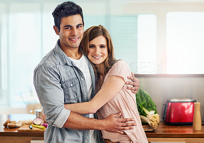 Buy stock photo Portrait of an affectionate young couple standing in the kitchen
