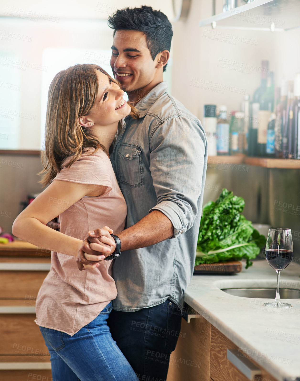 Buy stock photo Shot of an affectionate young couple dancing in the kitchen