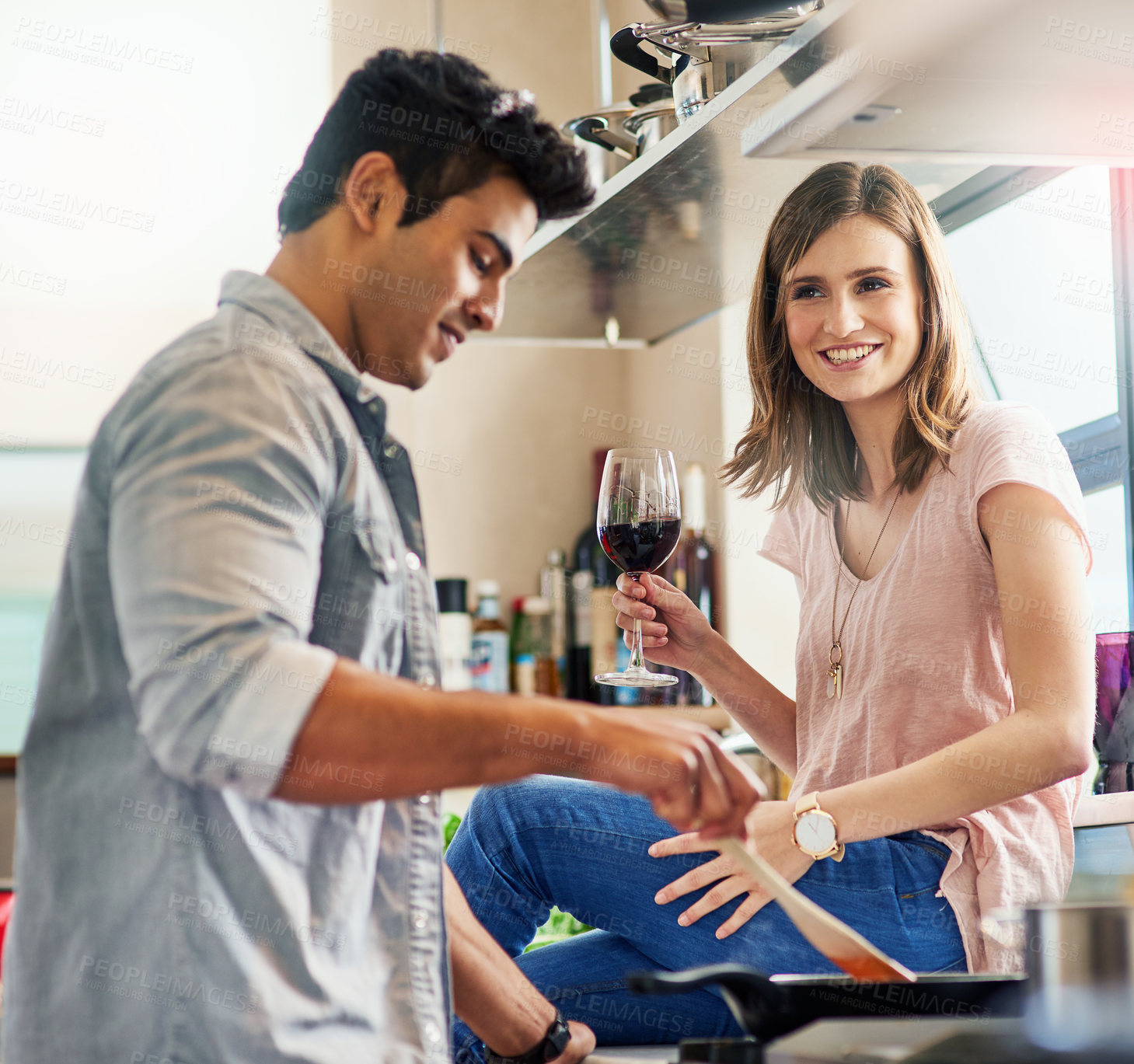 Buy stock photo Happy, couple cooking and toast together for bonding in kitchen over romantic meal preparation at home. Excited, man and woman with wine glasses and sauce pan for nutrition, alcohol and healthy food