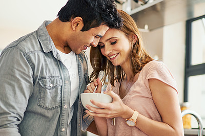 Buy stock photo Shot of an affectionate young couple standing in their kitchen